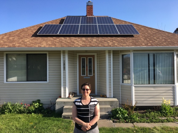 Nancy in front of her house with solar panels